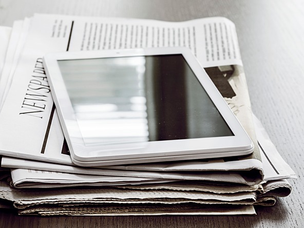 Newspapers and a tablet computer